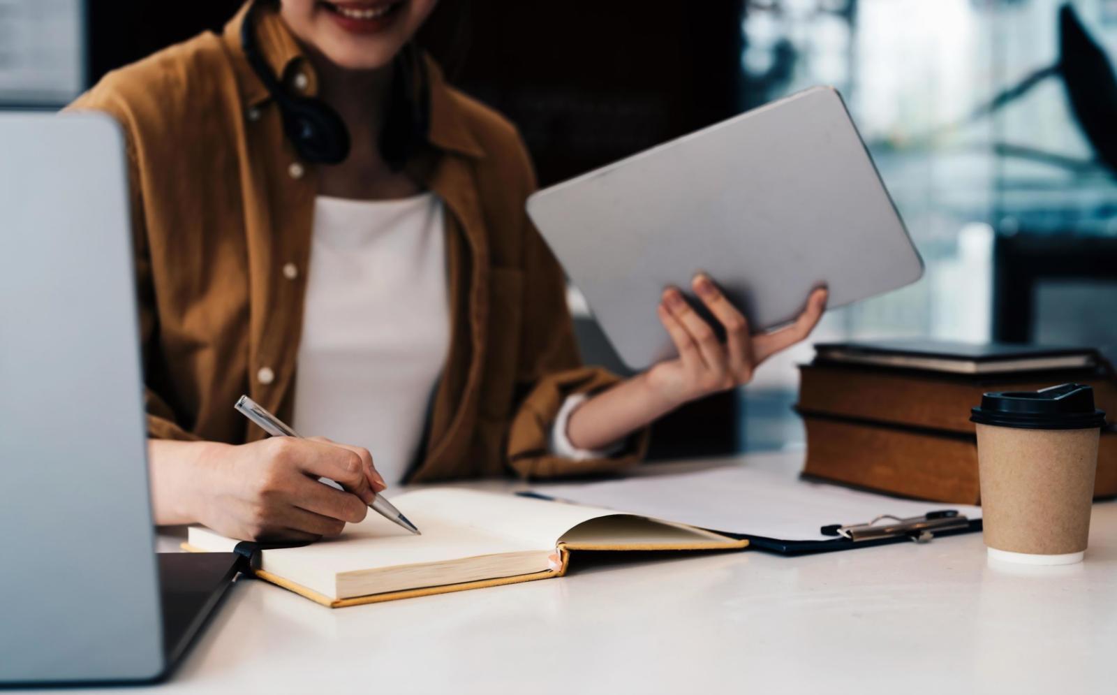 Estudiante organizando su espacio de estudio remoto con materiales de nutrición y planificación de comidas